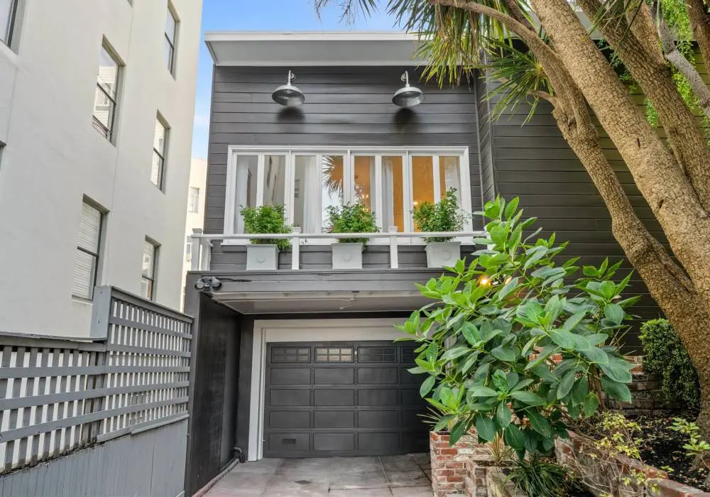 A house with a garage and balcony in the middle of it