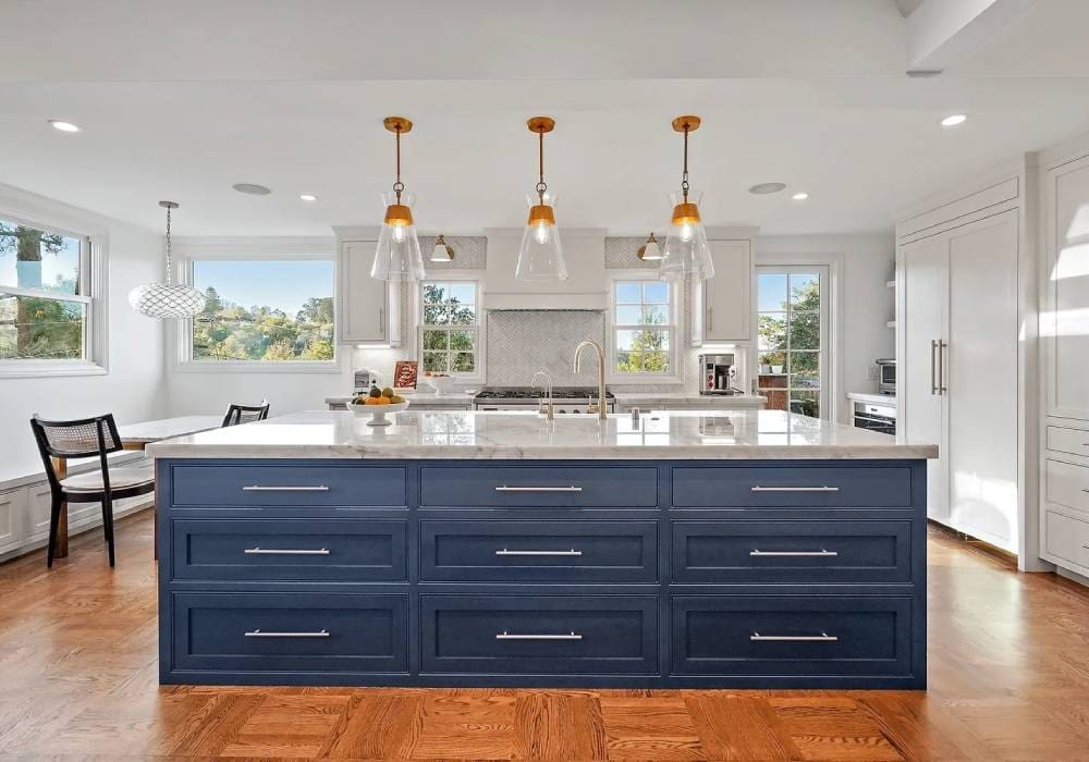 A kitchen with blue cabinets and white counters