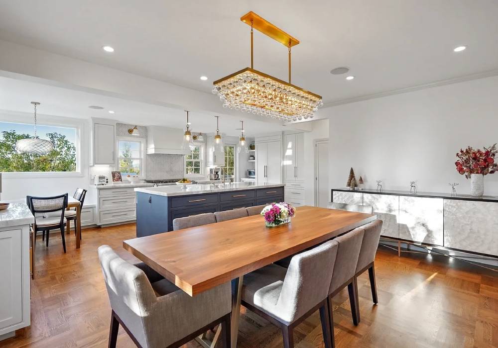 A dining room table with chairs and a chandelier.