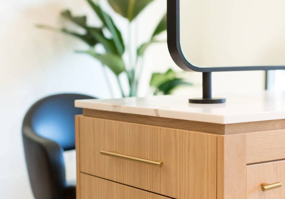 A wooden dresser with a mirror on top of it.