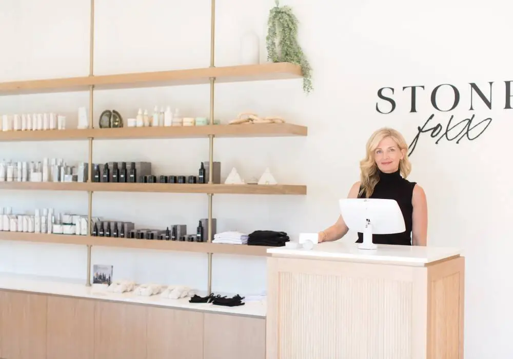 A woman standing behind the counter of a store.