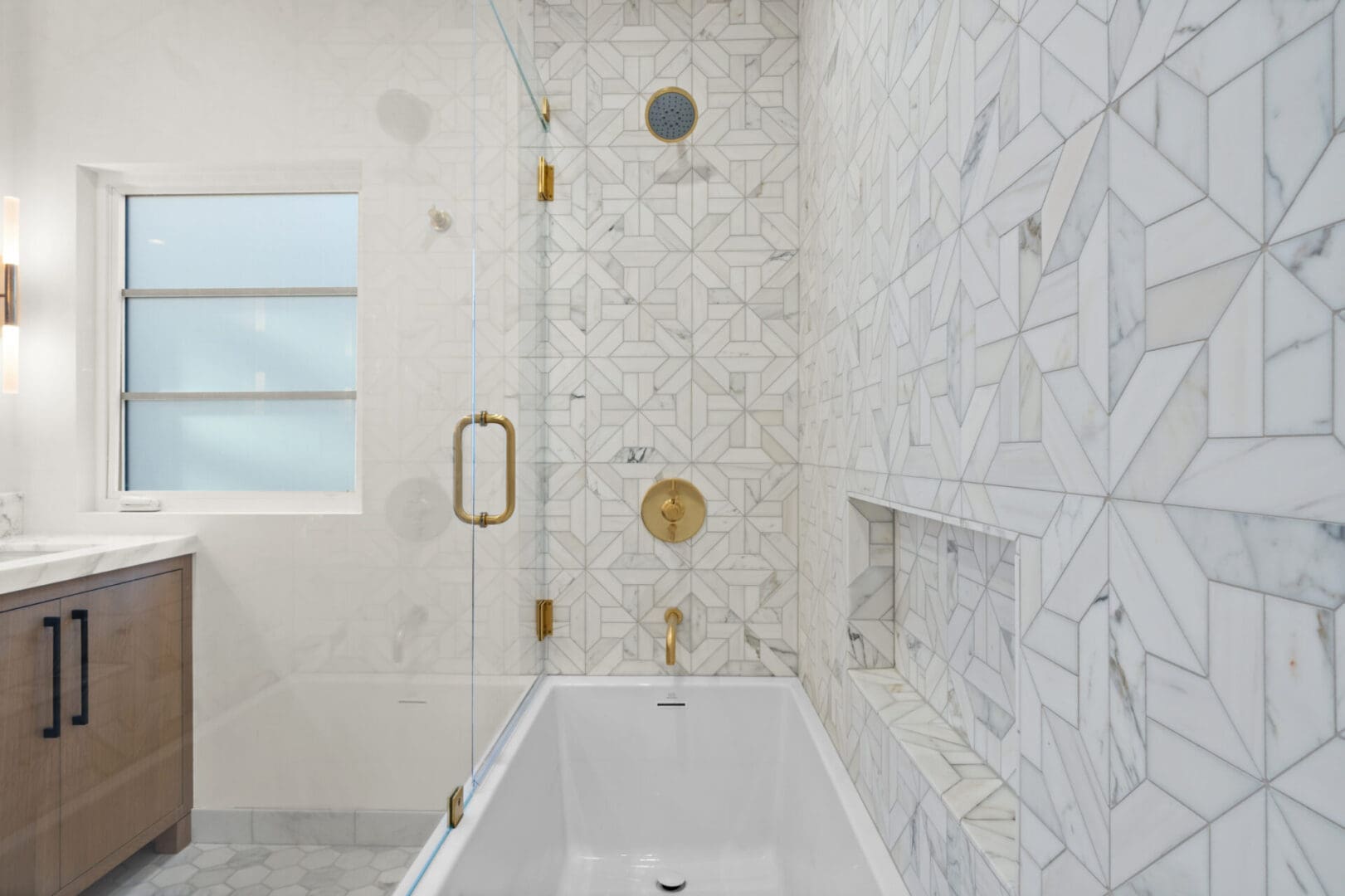 A bathroom with marble walls and gold fixtures.