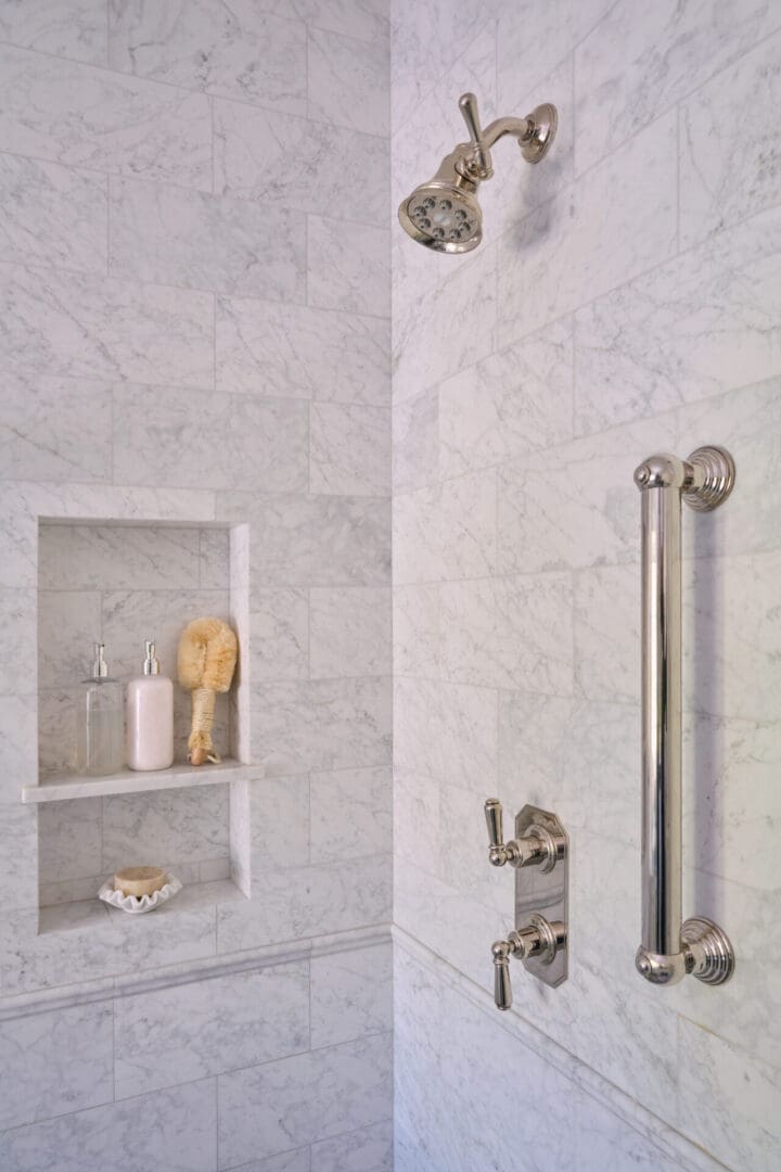 A bathroom with marble walls and white tile.