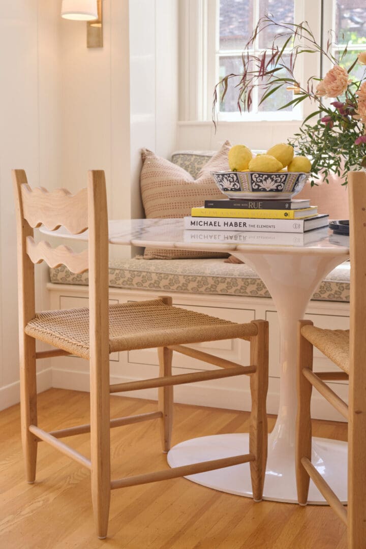 A table with two chairs and a bench in the background.