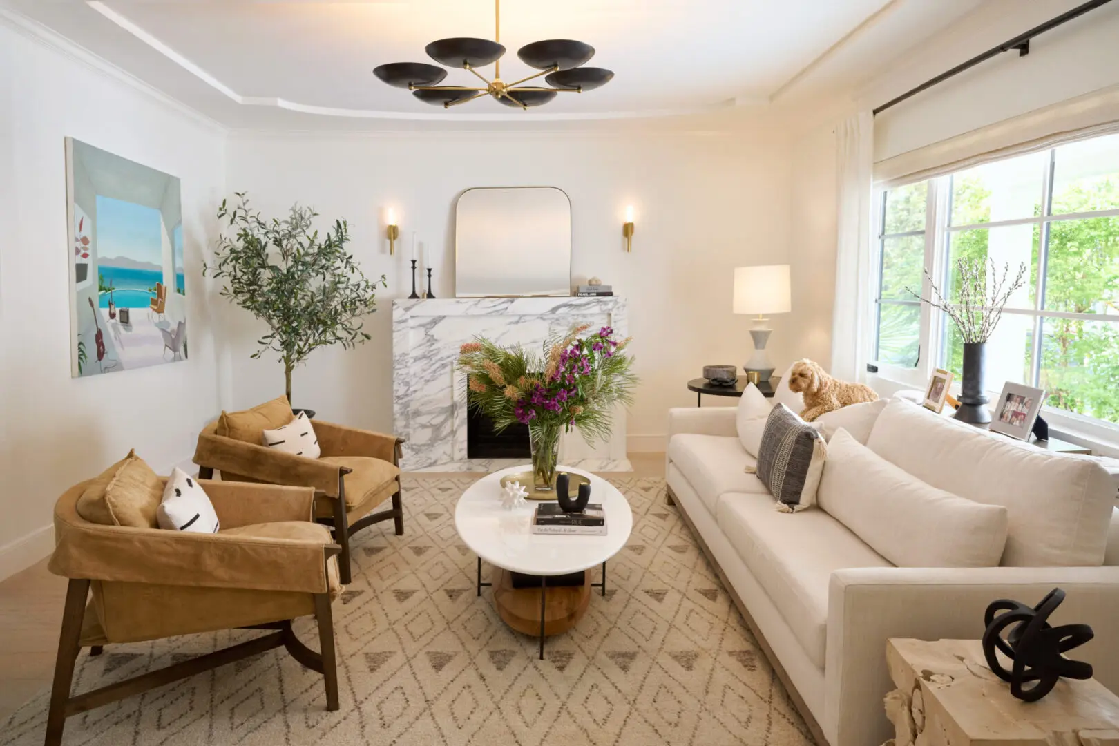 A living room with white furniture and a fireplace.