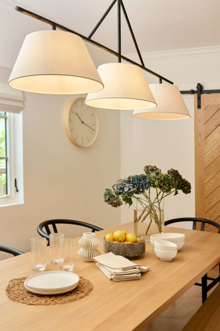 A dining room table with glasses and fruit on it.