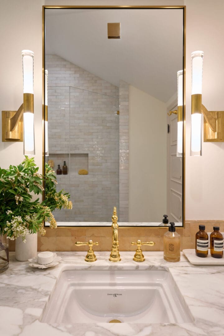 A bathroom with a sink, mirror and plants.